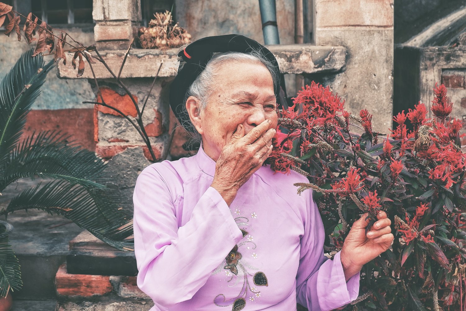 Elderly lady smiling with hand covering her mouth